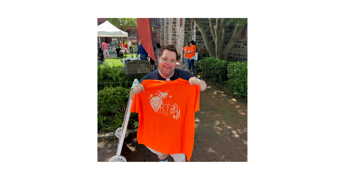 John proudly shows off his Art Crawl t-shirt with a big smile.