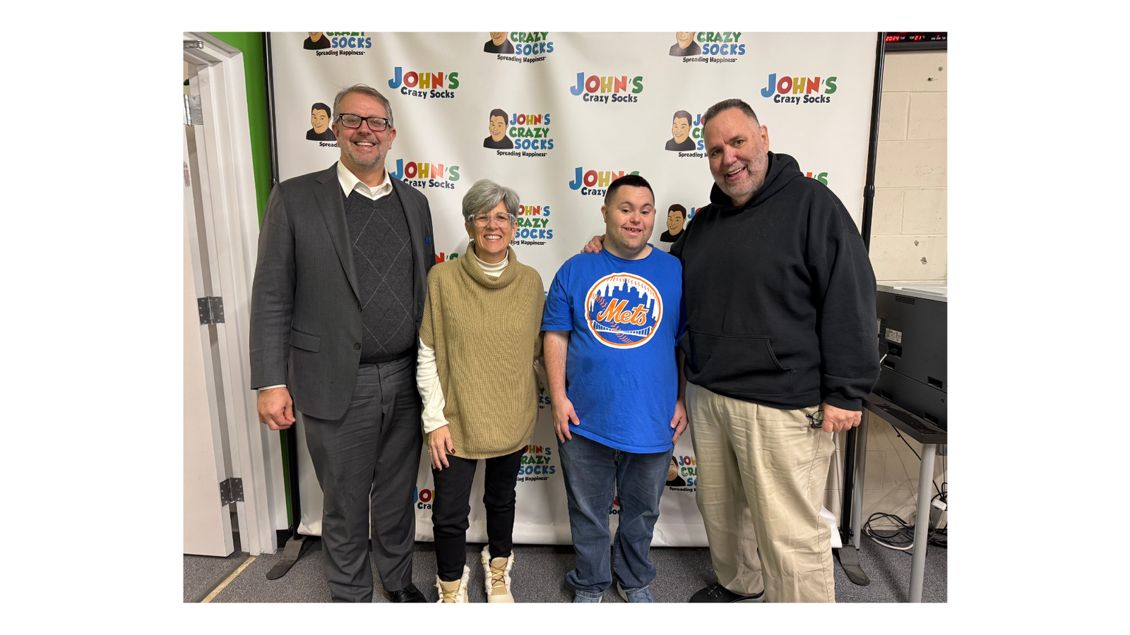 An image of John and Mark Cronin, co-founders of John’s Crazy Socks, with New York State Assemblyman Keith Brown and Susan Broderick, District Office Chief of Staff.