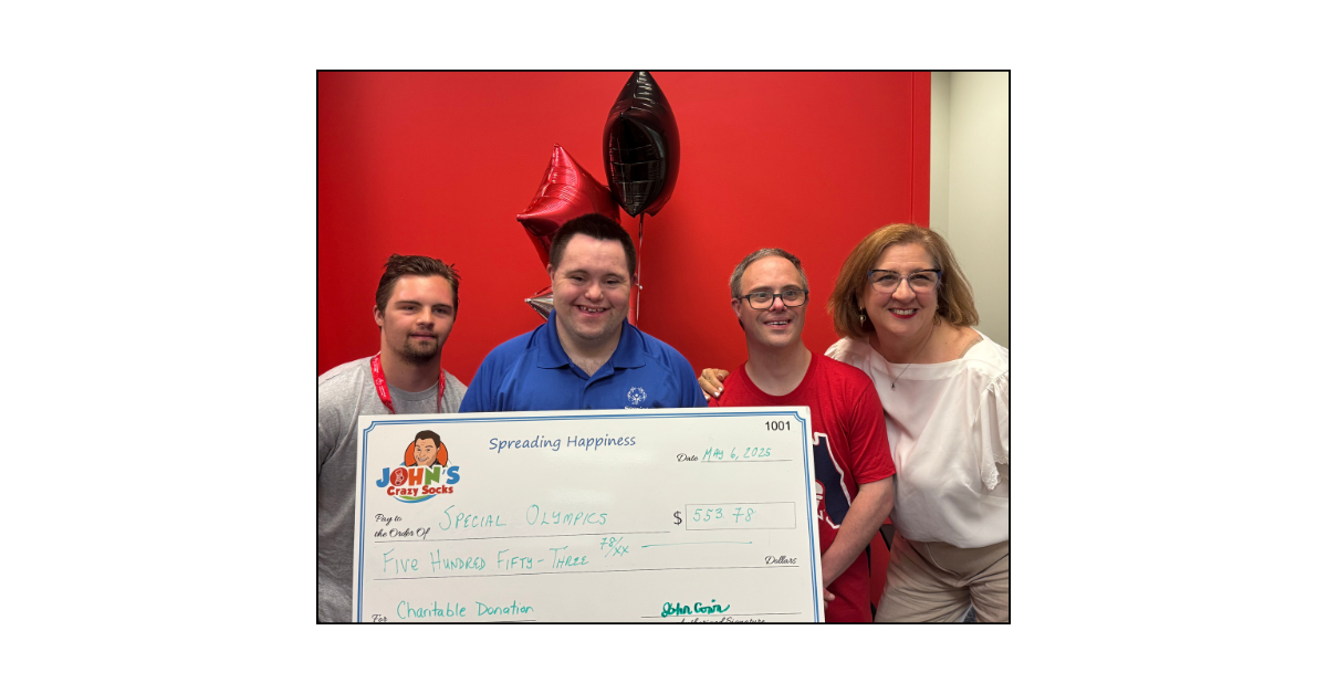 John Cronin proudly presents a donation check to Special Olympics New York, spreading joy and support with every smile.