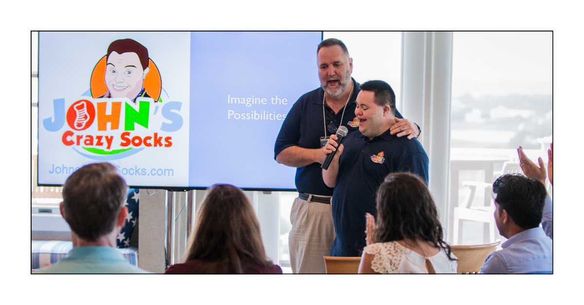 John and Mark X. Cronin on stage during a speaking engagement.